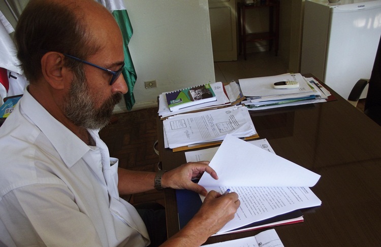 Prefeito assinando decreto.